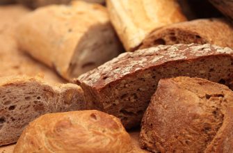Assorted rustic bread loaves with crusty brown crusts and airy crumb slices stacked together
